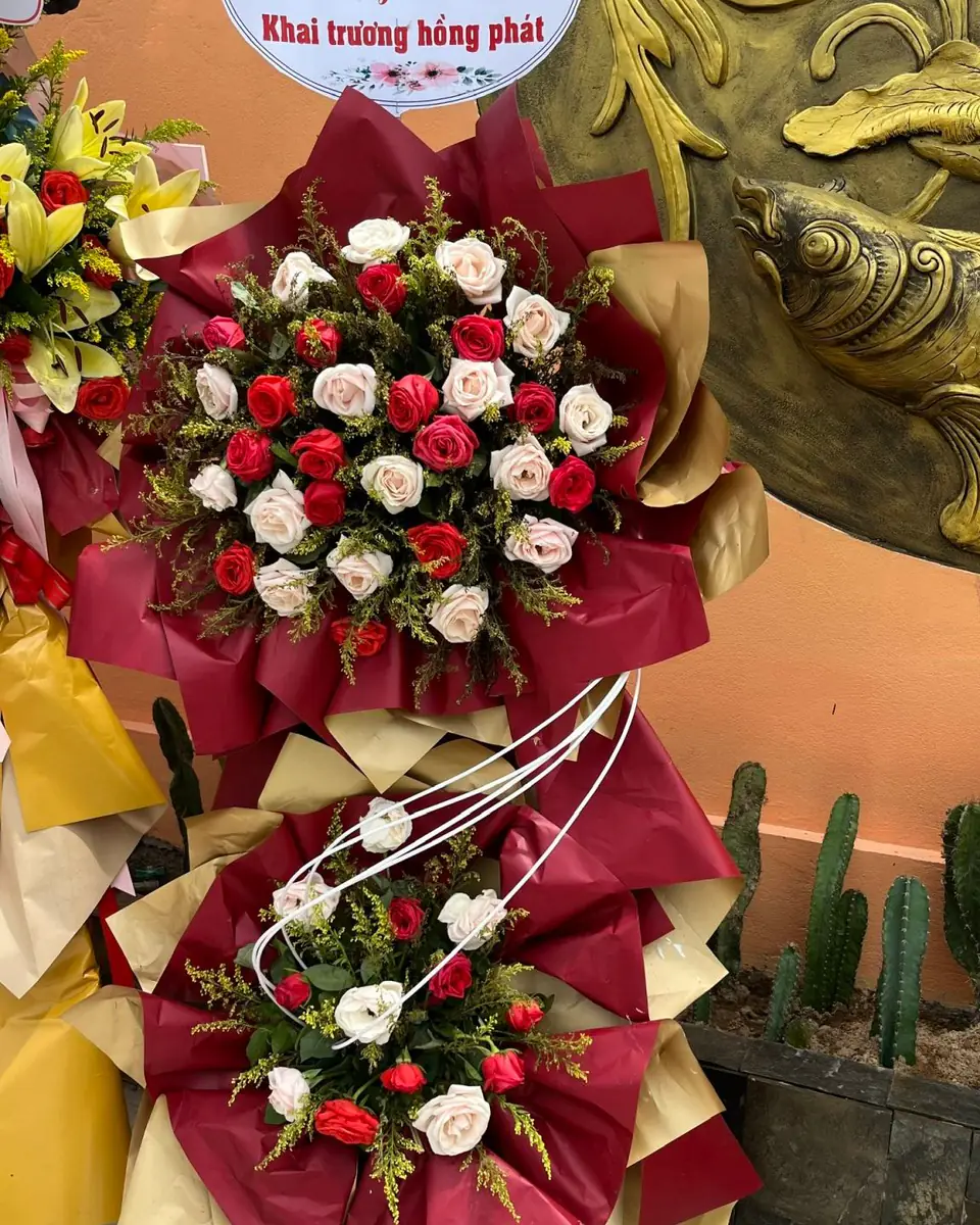 Kệ hoa khai trương hai tầng tông đỏ đô phối giấy vàng ánh kim, hoa hồng đỏ và trắng