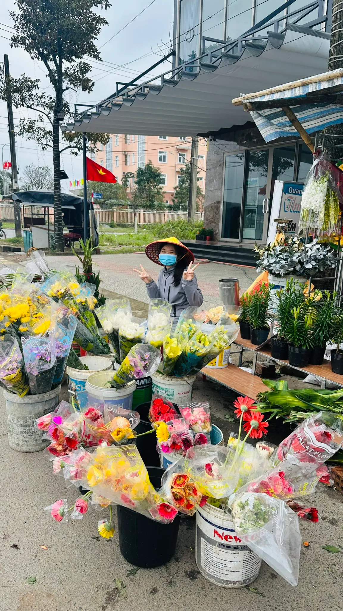 Sạp hoa ngoài trời buổi sáng, hoa bó nhiều màu cắm trong xô